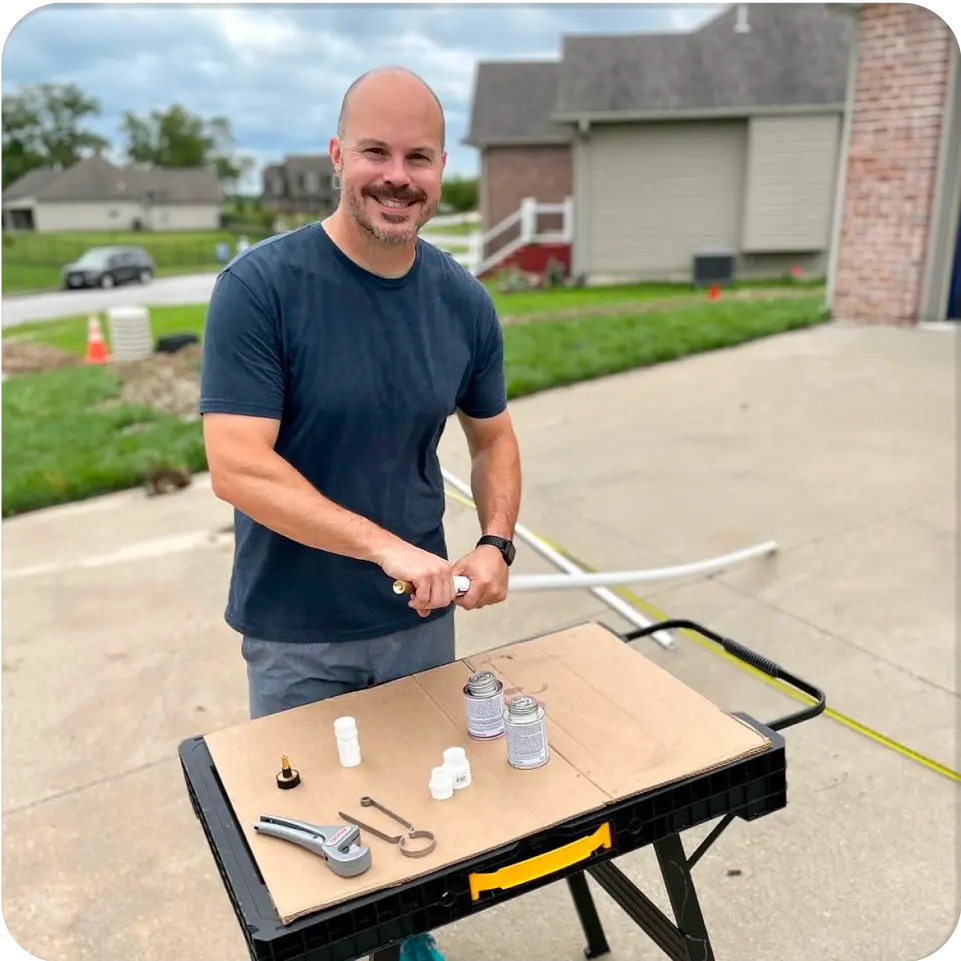 Professional Irrigation installer sealing together PVC piping in driveway